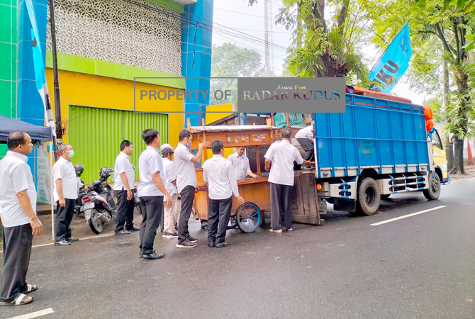 DIANGKUT TRUK: Gerobak PKL yang ditinggal langsung diangkut ke dalam truk. Lokasi utara stadion Bung Karno kawasan GOR Kudus kemarin. (INDAH SUSANTI/RADAR KUDUS)