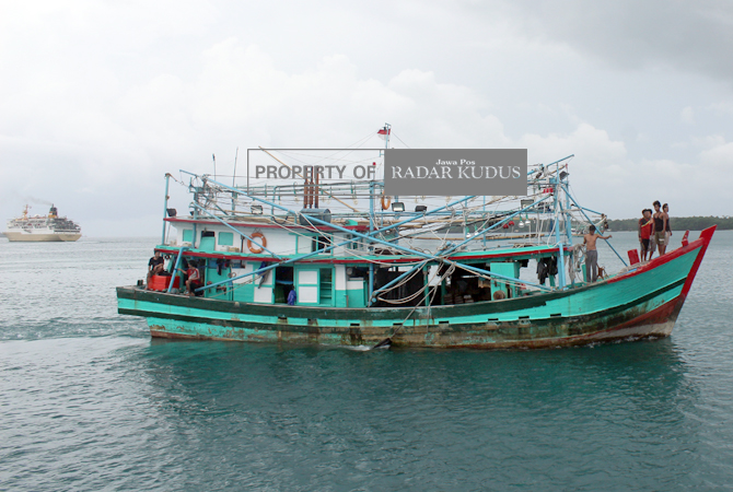 GELAP: Sebuah kapal nelayan yang bersandar di pelabuhan Legon Bajak, Kemujan berputar hendak memarkir kapal di lain lokasi saat cuaca mendung. (NIBROS HASSANI/JAWA POS RADAR KUDUS)