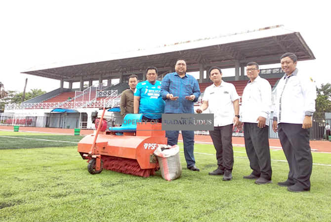 NYAMAN: CEO Persipa Pati Joni Kurnianto bersama General Manager Persipa Pati Dian Dwi Budianto menyerahkan bantuan granule kepada pengelola Stadion Joyokusumo kemarin. (ACHMAD ULIL ALBAB/RADAR KUDUS)