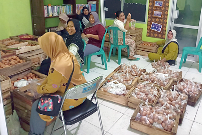 TATA ULANG: Tim sembako desa membungkus ulang paket sembako yang rusak karena  terhimpit satu sama lain saat di kapal. (ARIF FOR JAWA POS RADAR KUDUS)