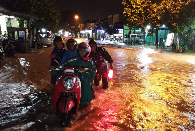 TERENDAM: Salah seorang pengendara terjebak banjir pada Rabu (15/2) malam. (GALIH ERLAMBANG W/RADAR KUDUS)