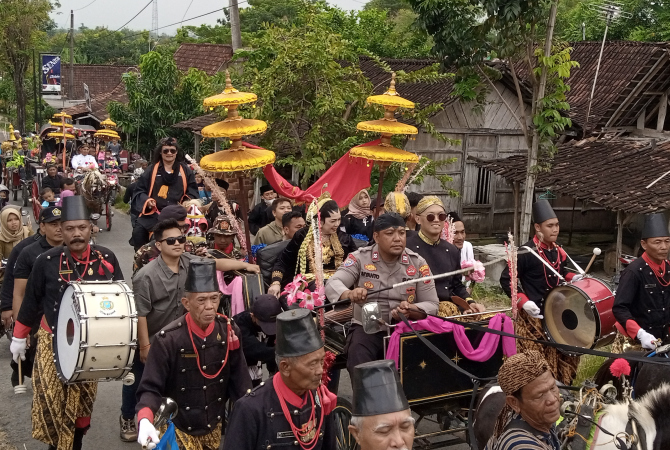 HORMAT: Syarifah Salma bin Hasyim bin Yahya (perempuan tengah) mengikuti acara kirab dengan naik kereta kuda. (EKO SANTOSO/RADAR KUDUS)