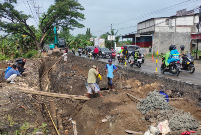 KEBUT: Pekerja memperbaiki Jalan Purwodadi-Semarang yang ambles, Rabu (22/2). (ANWAR FOR RADAR KUDUS)