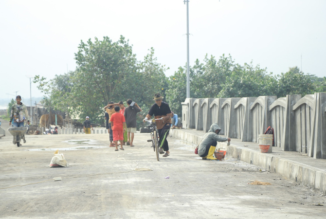 BESIH-BERSIH: Warga tampak antusias melihat jembatan di lingkar Sarang rampung kerjakan. (WISNU AJI/RADAR KUDUS)