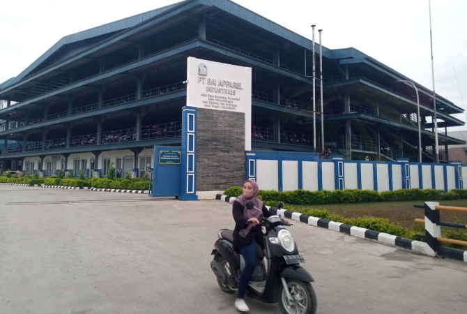 KELUAR: Salah seorang karyawan keluar dari tempat parkir perusahaan PT Sai Apparel Grobogan baru-baru ini. (EKO SANTOSO/RADAR KUDUS)