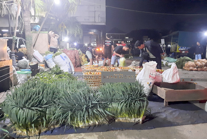 TAK MAU PINDAH: Pedagang sayur berjualan di pelataran Pasar Bitingan, Kudus, Minggu (5/2) malam. (DONNY SETYAWAN/RADAR KUDUS)
