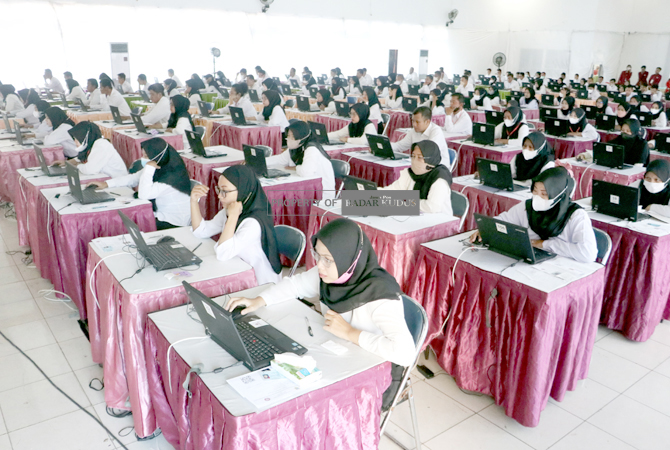 KONSENTRASI: Para peserta mengerjakan soal ujian pengisian perangkat desa serentak di Gedung Graha Mustika Desa Getas Pejaten, Jati, Kudus. (DONNY SETYAWAN/RADAR KUDUS)