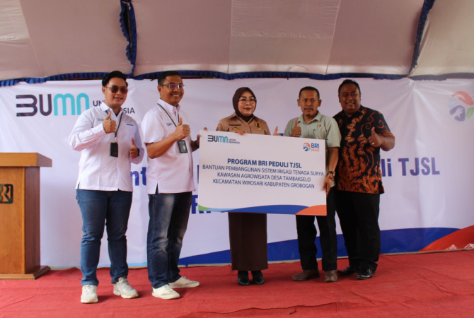 SERAHKAN BANTUAN: Pinca BRI Purwodadi Priyo Harjanto menyerahkan bantuan pembangunan sistem Irigasi Tenaga Surya Kawasan agrowisata Desa Tambakselo kepada Kades Tambakselo yang disaksikan Bupati Sri Sumarni pada Kamis (19/12). (SIROJUL MUNIR/RADAR KUDUS)