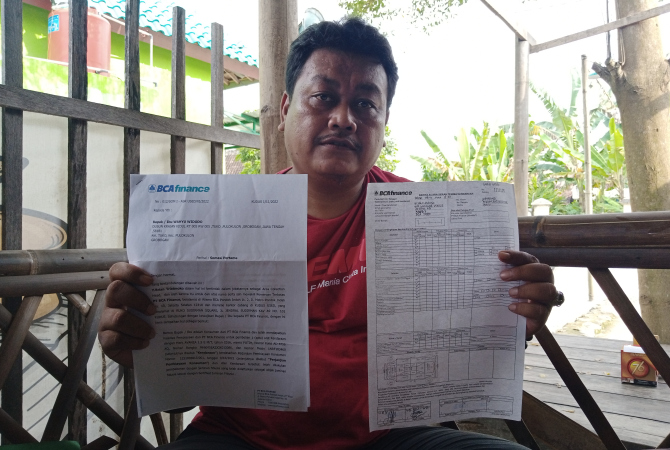 TUNJUKKAN: Wahyu Widodo warga Dusun Krajan Tuko, Pulokulon saat menunjukkan surat somasi dan bukti serah terima kendaraan, Minggu (19/3). (EKO SANTOSO/RADAR KUDUS)