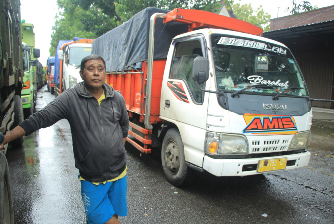 GELISAH: Wahyu, 56 sopir asal Sampang, Madura gelisah pasalnya 7 ton muatan ikannya nyaris busuk di jalan Gajahmada Rembang pada Kamis (2/3). (WISNU AJI/RADAR KUDUS)