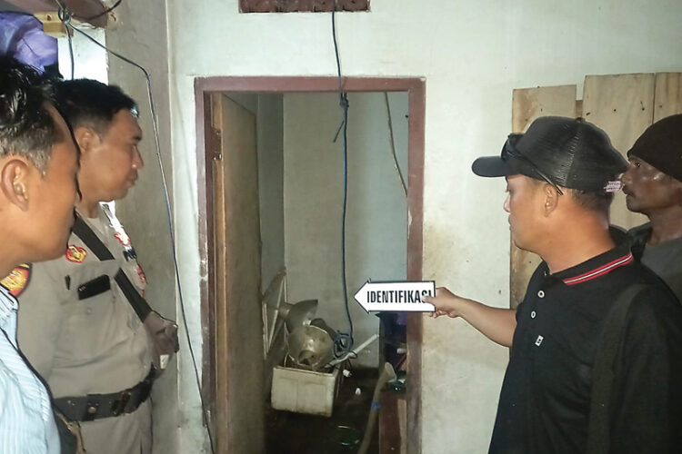 TRAGEDI: Anggota Polsek Pesanggaran melakukan olah TKP di lokasi gantung diri bocah SD di Desa Sumberagung, Banyuwangi, kemarin (28/2). (AKP Basori untuk Jawa Pos)
