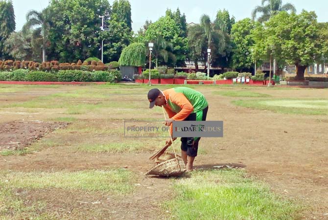 PULIHKAN ALUN-ALUN: Petugas kebersihan menyemprot Alun-alun Simpang Tujuh Kudus pada Sabtu (25/3). (ARIKA KHOIRIYA/RADAR KUDUS)