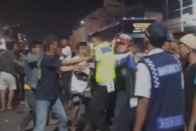 AMANKAN: Petugas kepolisian mencoba mengamankan pemuda asal Desa Ngemplak dan Desa Babagan yang terlibat perkelahian saat malam takbir keliling pada Jumat (21/4). (TANGKAPAN LAYAR ISTIMEWA)