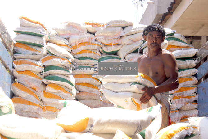 SIAP DISALURKAN: Belasan ton beras diangkut dari truk untuk di drop ke Aula Balai Desa Rendeng pada Rabu (12/4). (ARIKA KHOIRIYA/RADAR KUDUS)