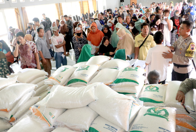 TAK TERTATA: Warga terlihat antre di aula Balai Desa Rendeng mengambil bantuan cadangan pangan pemerintah (CPP) beras yang didistribusikan Dinsos Kudus pada Kamis (13/4). (DONNY SETYAWAN/RADAR KUDUS)