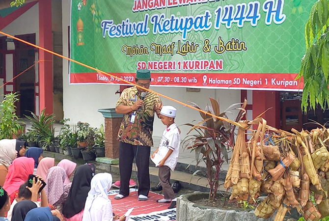 URI-URI BUDAYA: Kepala SD N 1 Kuripan Agung Budi Utomo memberikan sambutan di depan ratusan siswa untuk mengenalkan tradisi kupatan di depan kelas, kemarin. (SIROJUL MUNIR/RADAR KUDUS)