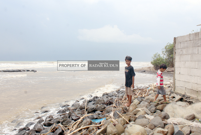MENGKHAWATIRKAN: Anak-anak sekitar Pantai Bringin, Desa Bumiharjo, Keling, Jepara, bermain di pinggiran pantai yang sudah terkena abrasi hingga mencapai rumah warga. (NIBROS HASSANI/JAWA POS RADAR KUDUS)