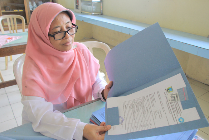 SULIT CARI MURID: Salah satu panitia mengecek berkas PPDB di ruang sekretariat SMPN 4 Rembang pada Rabu (24/5). (WISNU AJI/RADAR KUDUS)