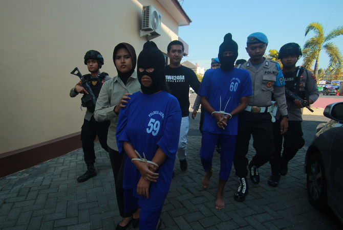 TEGA: Pasutri tersangka pembuangan bayi ke dalam sumur asal Kembang, Jepara, dikeler polisi saat dihadirkan dalam konferensi pers di Mapolres Jepara pada Senin (22/5). (MOH. NUR SYAHRI MUHARROM/RADAR KUDUS)