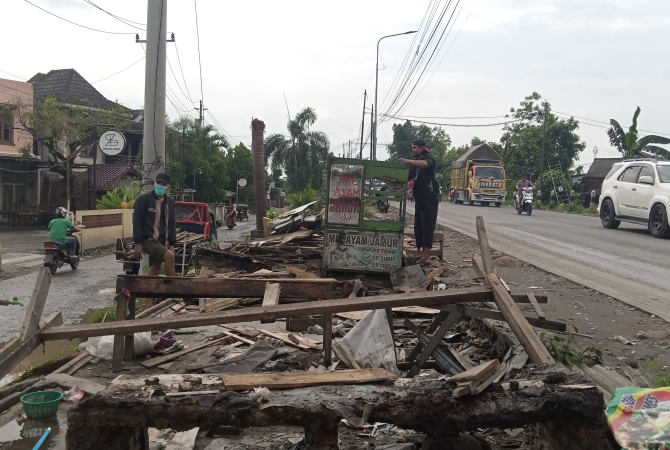 KOOPERATIF: Pedagang saat mengambil puing-puing bongkaran lapak yang berada di pinggir Jalur Lingkar Gubug yang telah dibongkar pada Senin (8/5). (EKO SANTOSO/RADAR KUDUS)