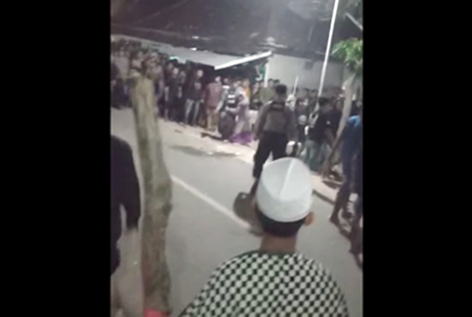 Tangkapan layar seorang pemuda mengayunkan tebasan celurit di kerumunan massa saat pagelaran orkes dangdut di Sedan, Rembang, Minggu (30/4). (Tangakapan layar video)