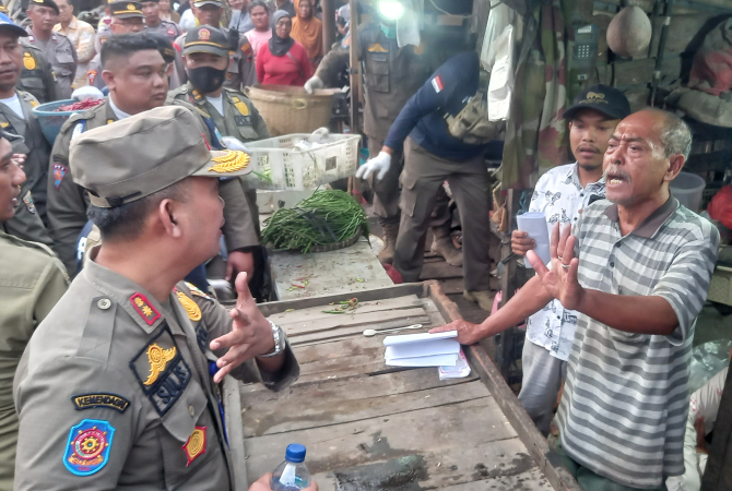 ADU ARGUMEN: Tim Satpol PP adu argumentasi dengan pedagang saat upaya pembongkaran lapak di luar pagar Pasar Rembang kemarin. Sejumlah petugas mengakut barang-barang para pedagang. (VACHRI RINALDY L/RADAR KUDUS)