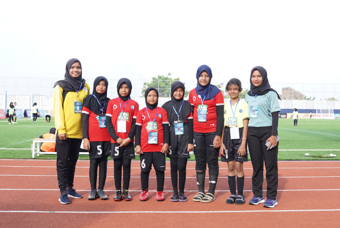 KOMITMEN: Sebagai guru, Isnaeni Amrina Rusdah (kiri baju kuning) dari sekolah MIM Al Tanbih dan Ana Ariani dari SD 2 Getas Pejaten Kudus mengabadikan momen bersama para anak didiknya saat mengikuti kejuaraan MilkLife Soccer Challenge 2023 di Supersoccer A