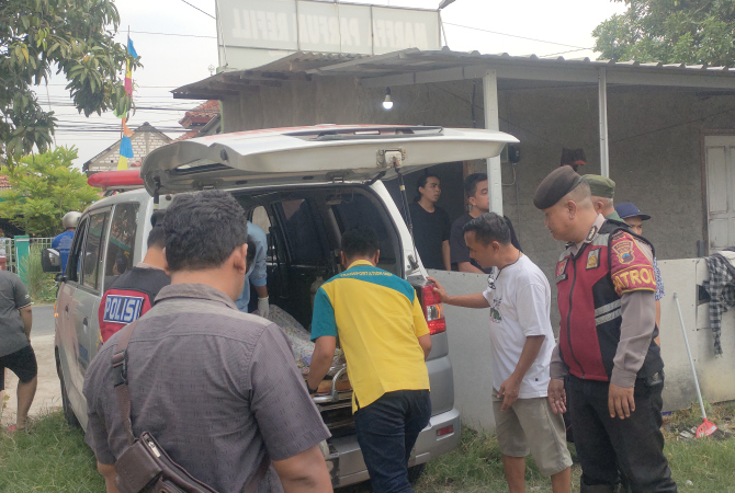 JENAZAH: Polisi dibantu petugas kesehatan dan kerabat memasukkan jenazah ke dalam ambulans pada Kamis (15/6). (WISNU AJI/RADAR KUDUS)
