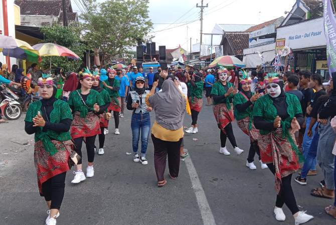 MERIAH: Ibu-ibu menari di jalan meramaikan karnaval Desa Sumberjo, Rembang pada Minggu (11/6). (VACHRI RINALDY L/RADAR KUDUS)