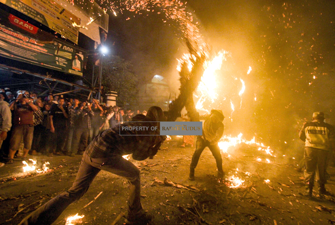 BERKOBAR: Peserta perang Festival Perang Obor di Desa Tegalsambi, Tahunan, Jepara, saling memukulkan dengan obor yang terbuat daun kelapa kemarin malam. (MOH. NUR SYAHRI MUHARROM/RADAR KUDUS)