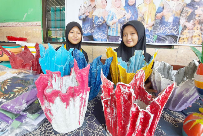 KREATIF: Musdalifah (kiri) bersama temannya menunjukkan pot dari bahan kain perca saat gelar karya di SD 1 Kajeksan. (INDAH SUSANTI/RADAR KUDUS)