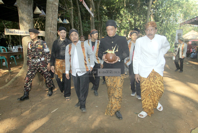SAKRAL: Petinggi Sukosono Zainal Arifin (tengah) memimpin kirab Air Panguripan dari delapan sumber mata air keliling Desa Sukosono kemarin. (MOH. NUR SYAHRI MUHARROM/RADAR KUDUS)