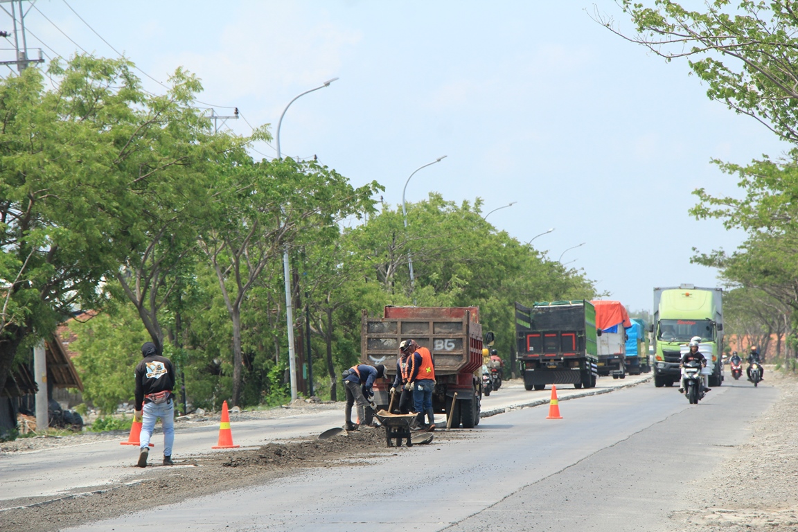 Lubang cor di bagian tengah Jalan Pantura Kaliori Rembang ditutup dengan sisa material pengaspalan.