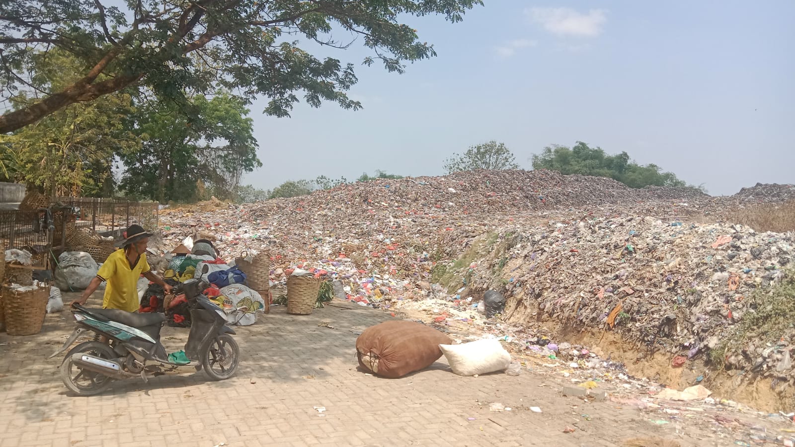 MENGGUNUNG: Seorang pemulung di TPA Landoh menyiapkan kendaraan untuk mengangkut sampah.