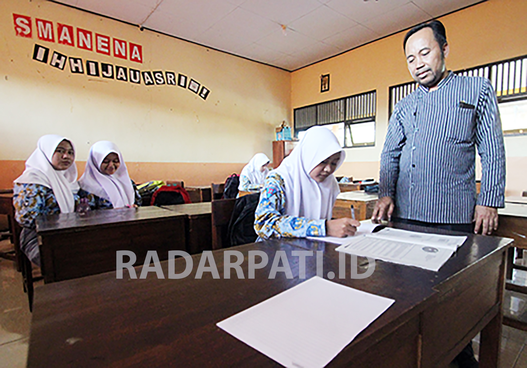 TERUS DIENTASKAN: Seorang guru memberi penjelasan kepada para siswa sebuah SMA negeri di Jepara.(MOH. NUR SYAHRI MUHARROM)