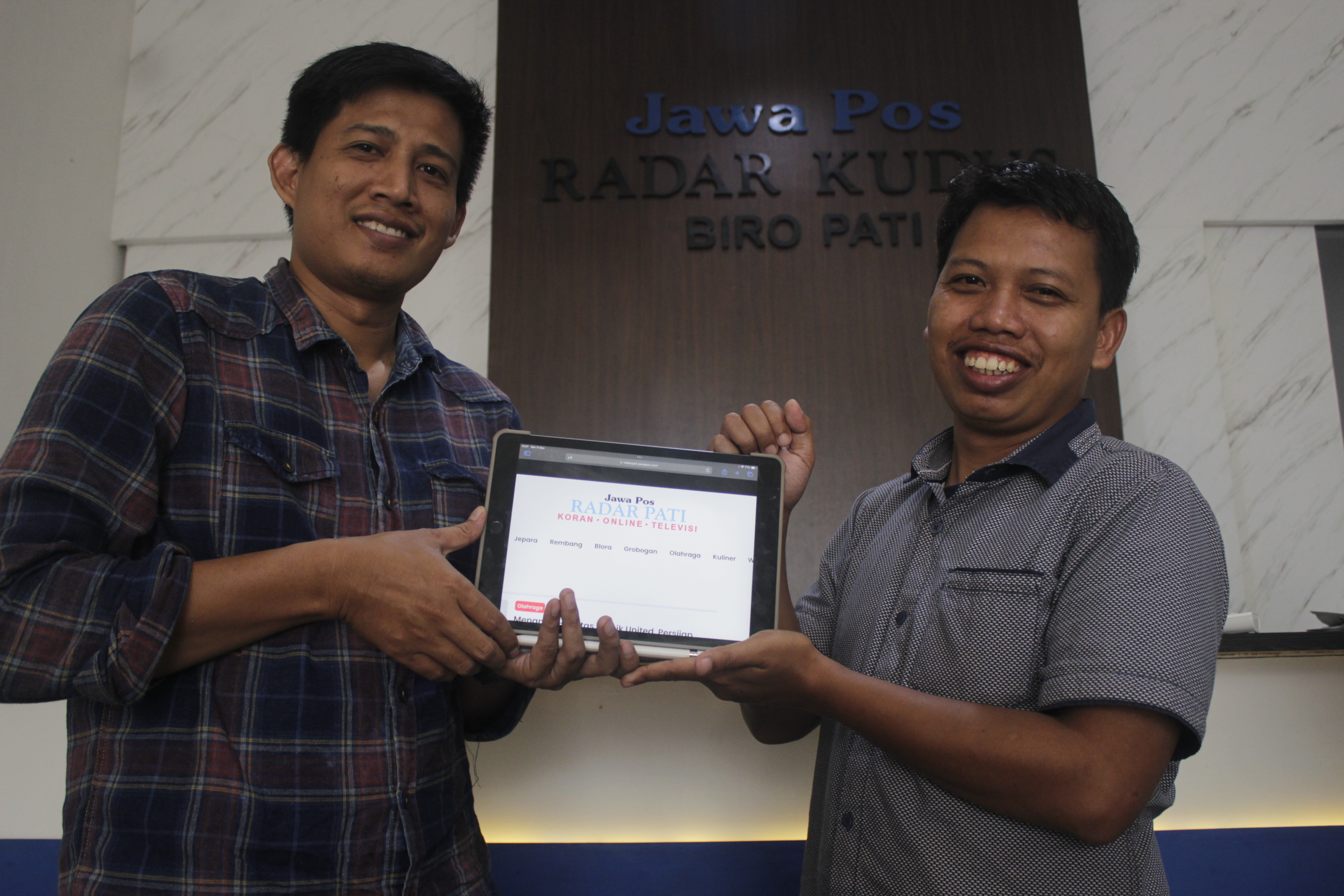 BERKEMBANG: Kepala Biro Radar Pati Abdul Rochim (kiri) bersama Pimred Radar Kudus Zaenal Abidin (kanan) menunjukkan halaman portal berita Radarpati.id.