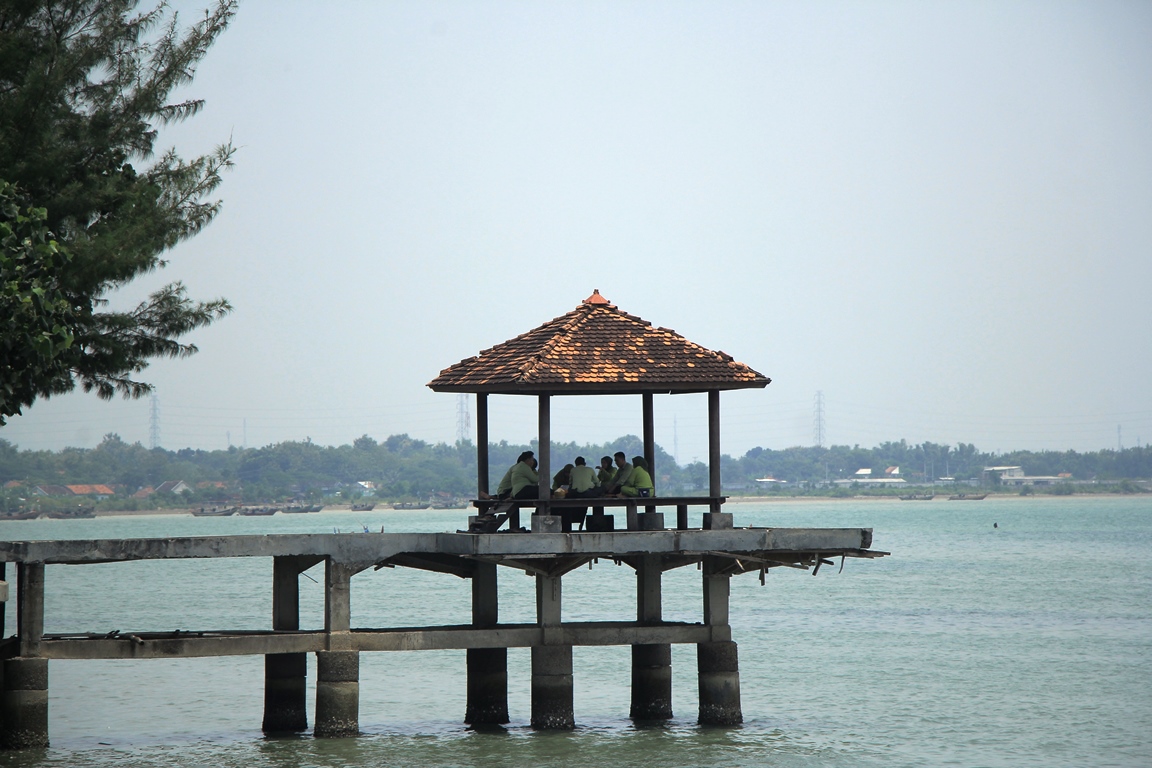 MENUNGGU SENJA: Sepasang muda-mudi gunakan menunggu matahari terbenam di Pantai Binangun. (WISNU AJI/RADAR KUDUS)