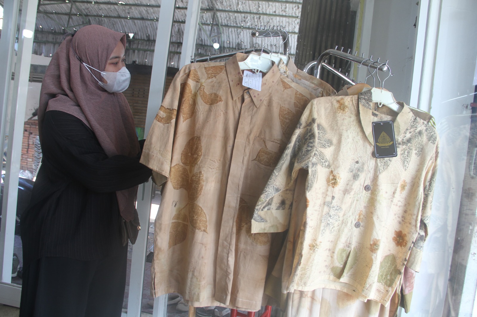 SALAH SATU PRODUK BERPOTENSI EKSPOR : Seorang perempuan tengah merapikan baju ecoprint di salah satu outlet di Kudus.