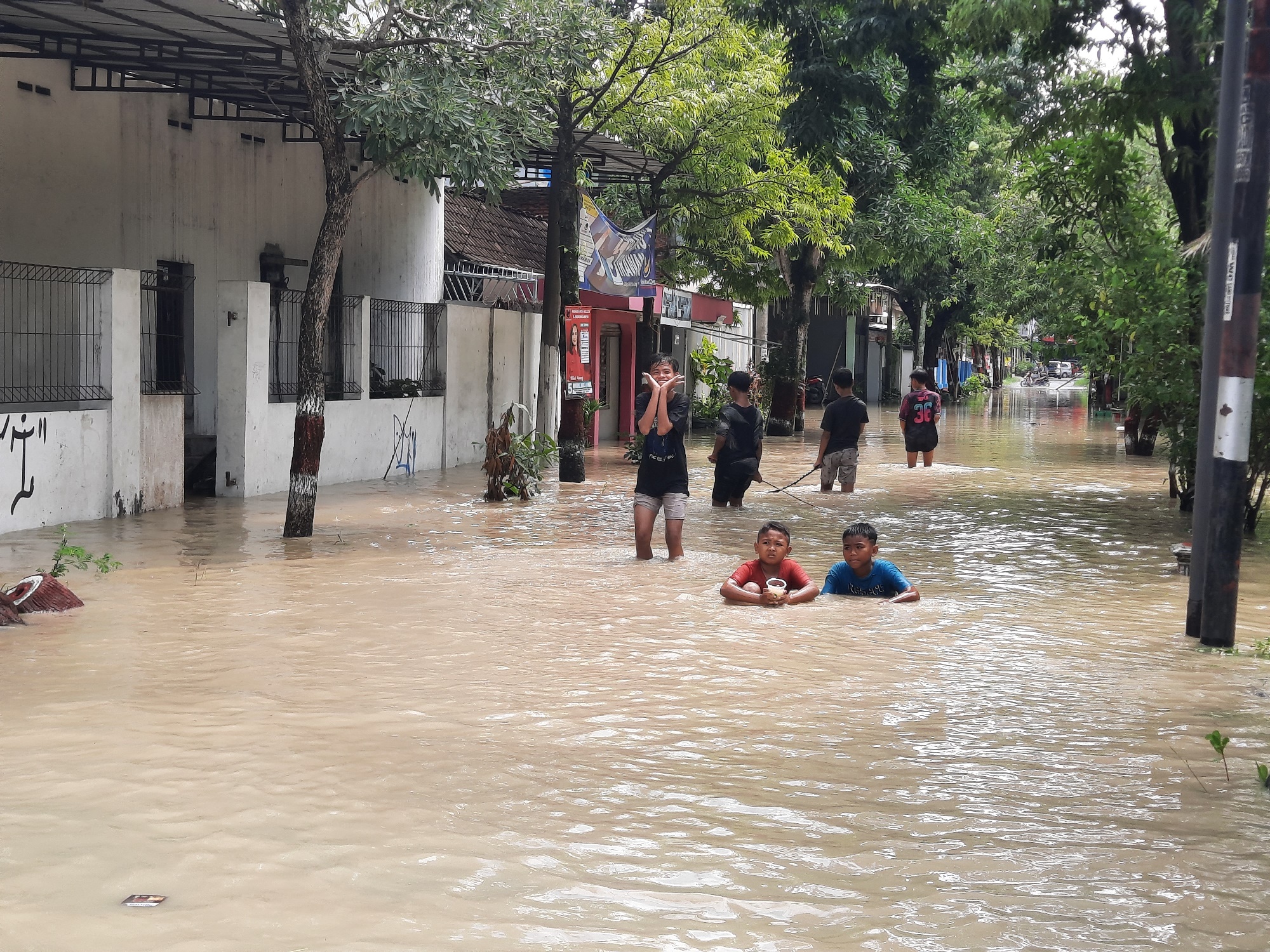 BERMAIN: Sejumlah anak saat bermain di lokasi banjir di Kota Purwodadi kemarin.