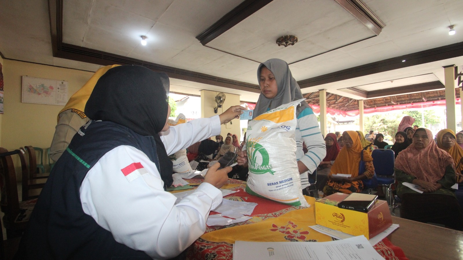 ADA CATATAN: Petugas membagikan bantuan beras CPP kepada masyarakat di Balai Desa Senenan belum lama ini. (MOH. NUR SYAHRI MUHARROM/RADAR KUDUS)