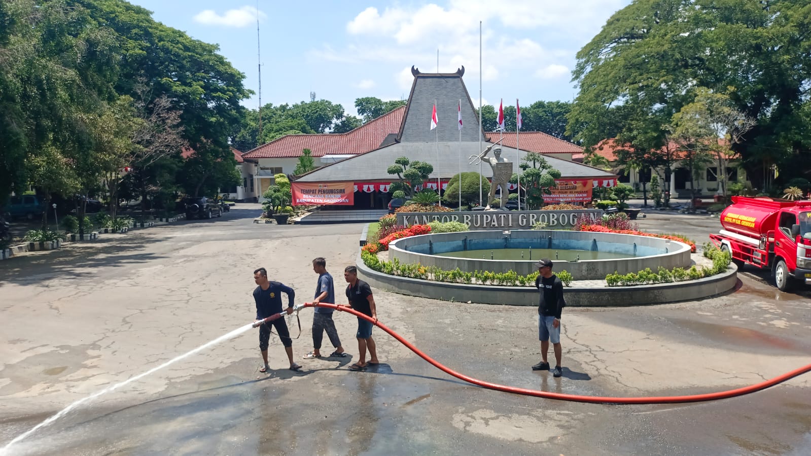 KERING: Petugas pemadam kebakaran melakukan pembersihan lumpur sisa banjir di lokasi Pendapa Kantor Bupati Grobogan, Kamis (8/2).