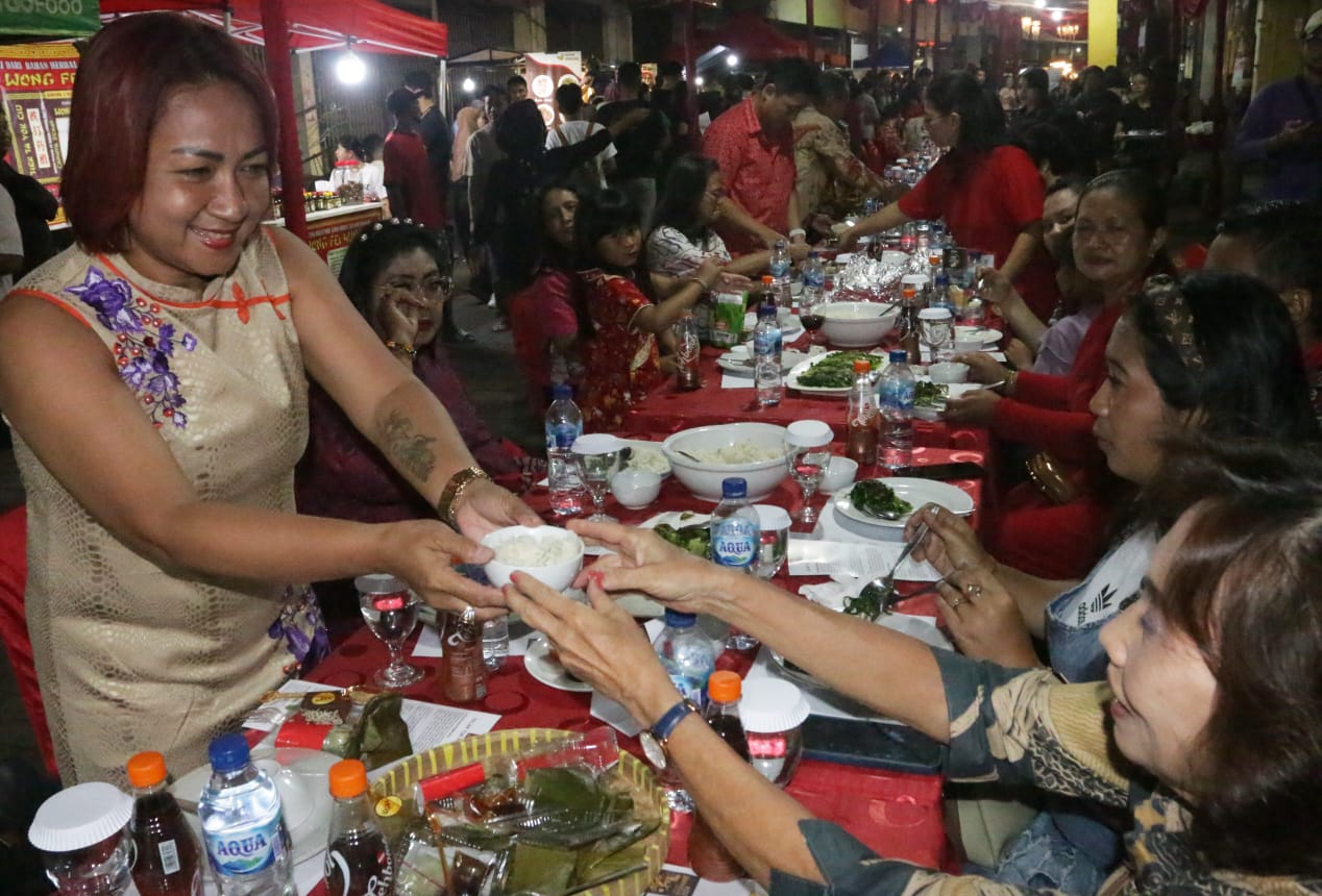 AKULTURASI : Warga mengikuti acara Tuk Panjang yang digelar di Kawasan Gang Warung, atau Pasar Semawis, Pecinan Semarang, Kamis (8/2) malam. (NURCHAMIM/JAWA POS RADAR SEMARANG)