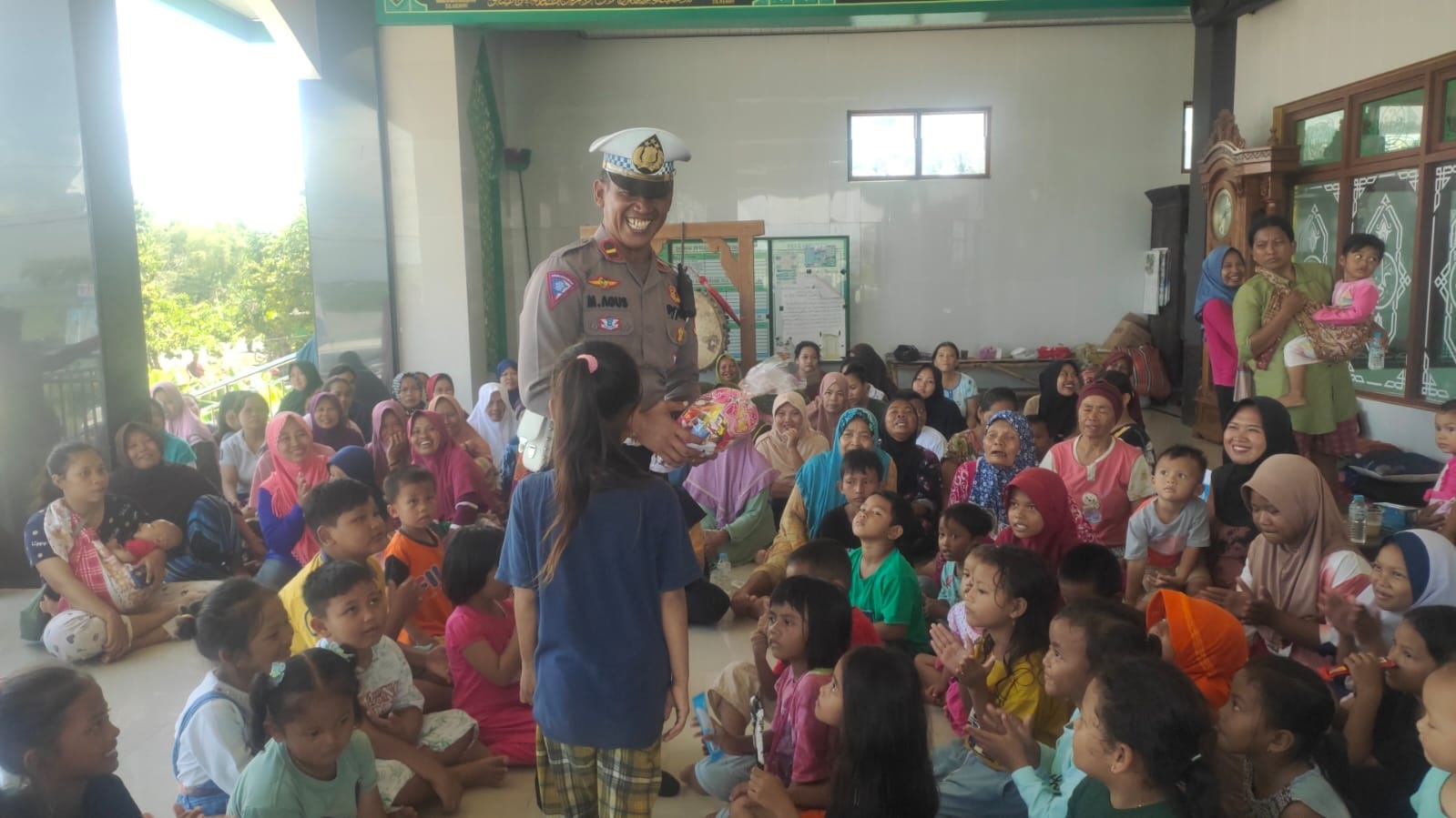 PEDULI: Anggota Unit Kamsel Satlatas Polres Grobogan saat melakukan trauma healing ke anak-anak korban bencana banjir di Desa Kemiri Kecamatan Gubug kemarin.