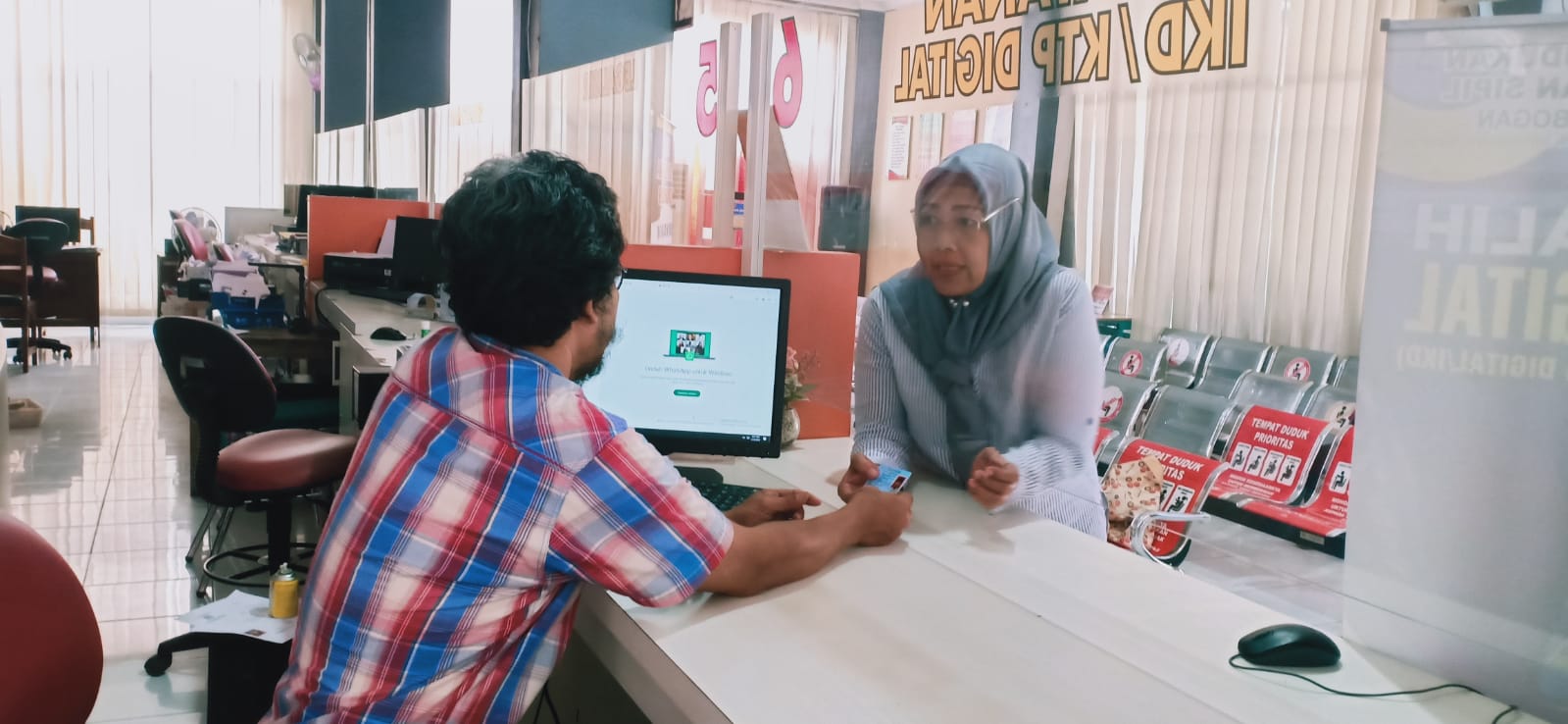 MELAYANI: Petugas Dispendukcapil Grobogan melayani masyarakat merekam E-KTP.