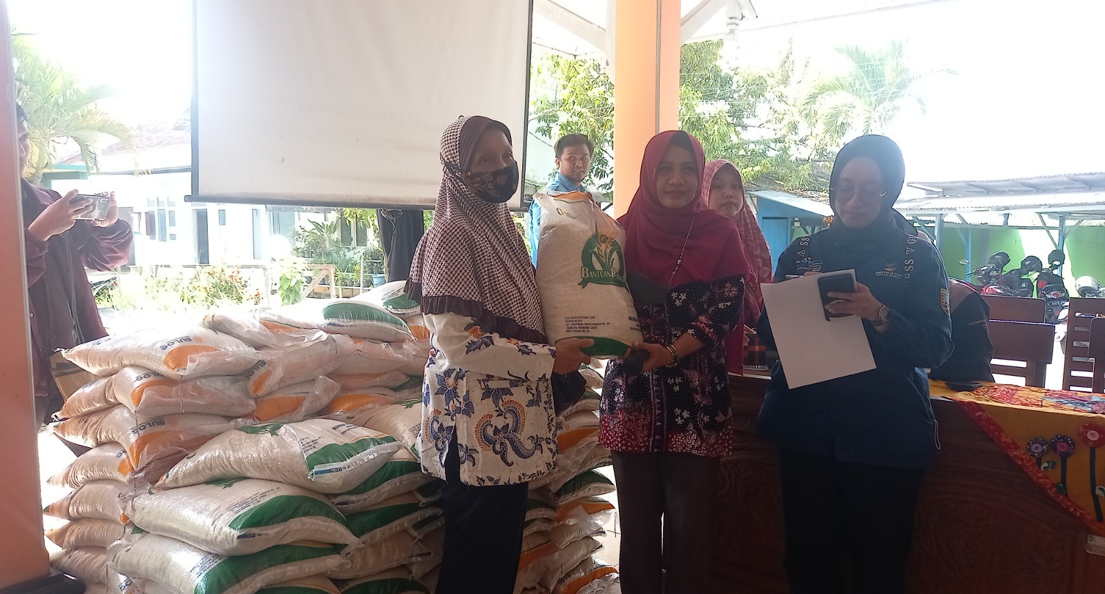 PENERIMA MANFAAT: Seorang warga menerima bantuan beras saat penyerahan yang dilaksanakan di Kantor Kecamatan Rembang beberapa waktu lalu.&nbsp;VACHRI RINALDY L/RADAR KUDUS