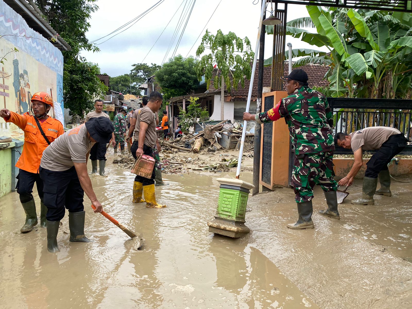 KERJA BHAKTI: Anggota TNI dan Polri melakukan kerja bhakti membersihkan lumpur di perumahan warga di Desa/Kecamatan Gubug, kemarin.