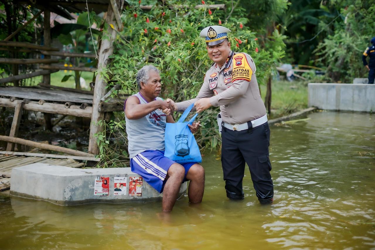 BANTUAN: Kasat Lantas Polres Grobogan AKP Tejo Suwono saat memberikan bantuan ke lokasi banjir di Dusun Mlakas Desa Lemah Putih Kecamatan Brati.