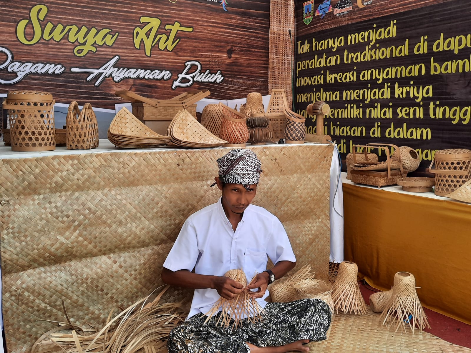 BUAT KERAJINAN: Perajin mengayam bambu untuk dijadikan produk seperti lampu hias, saat mengikuti pameran UMKM baru-baru ini.