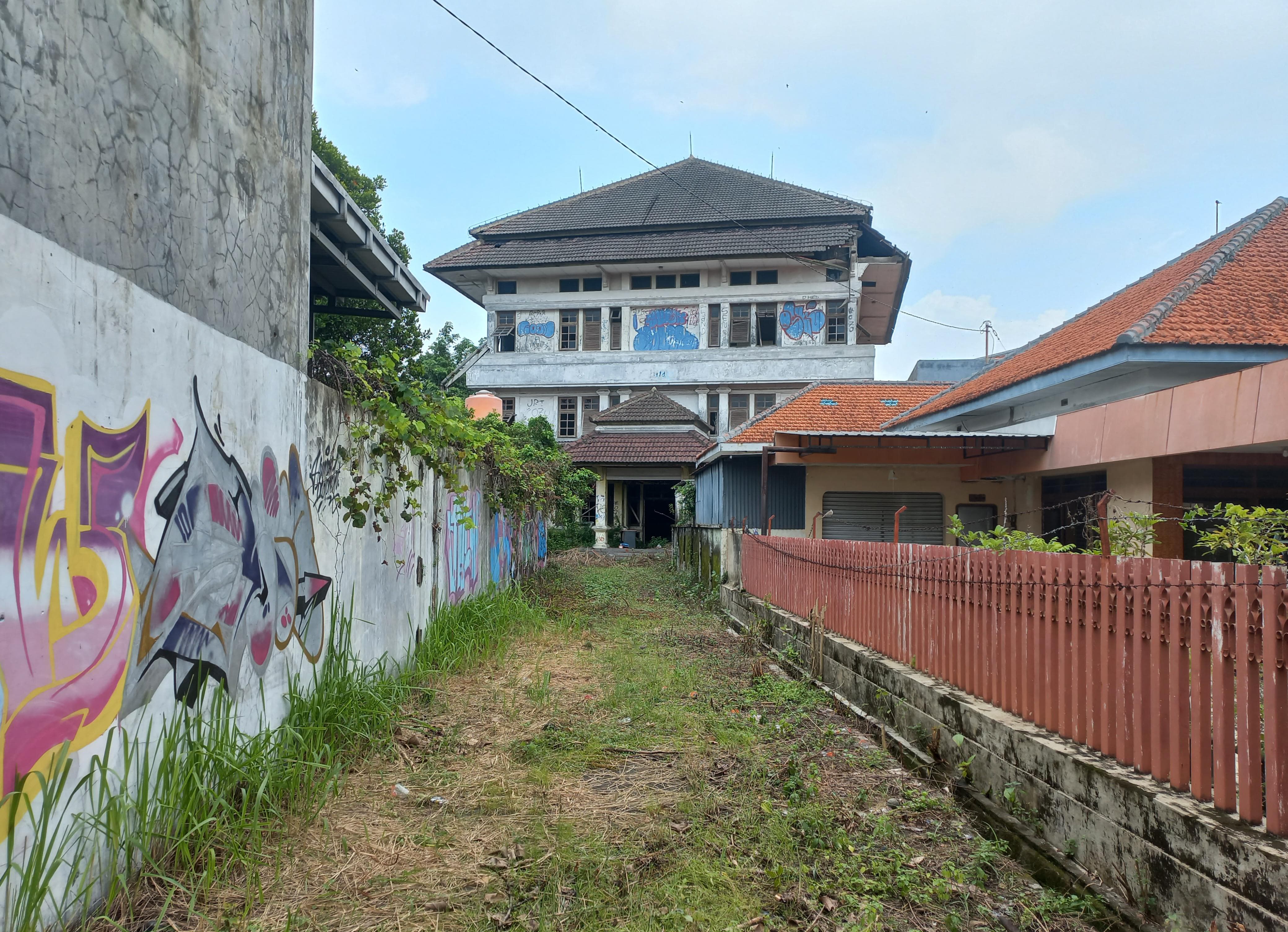 RUSAK: Hampir 20 tahun terbengkalai, kondisi eks Gedung Telkom memprihatinkan. Bangunan itu ditumbuhi tanaman liar dan beberapa sisi atap ambruk kemarin. (FIKRI THOHARUDIN/RADAR KUDUS)
