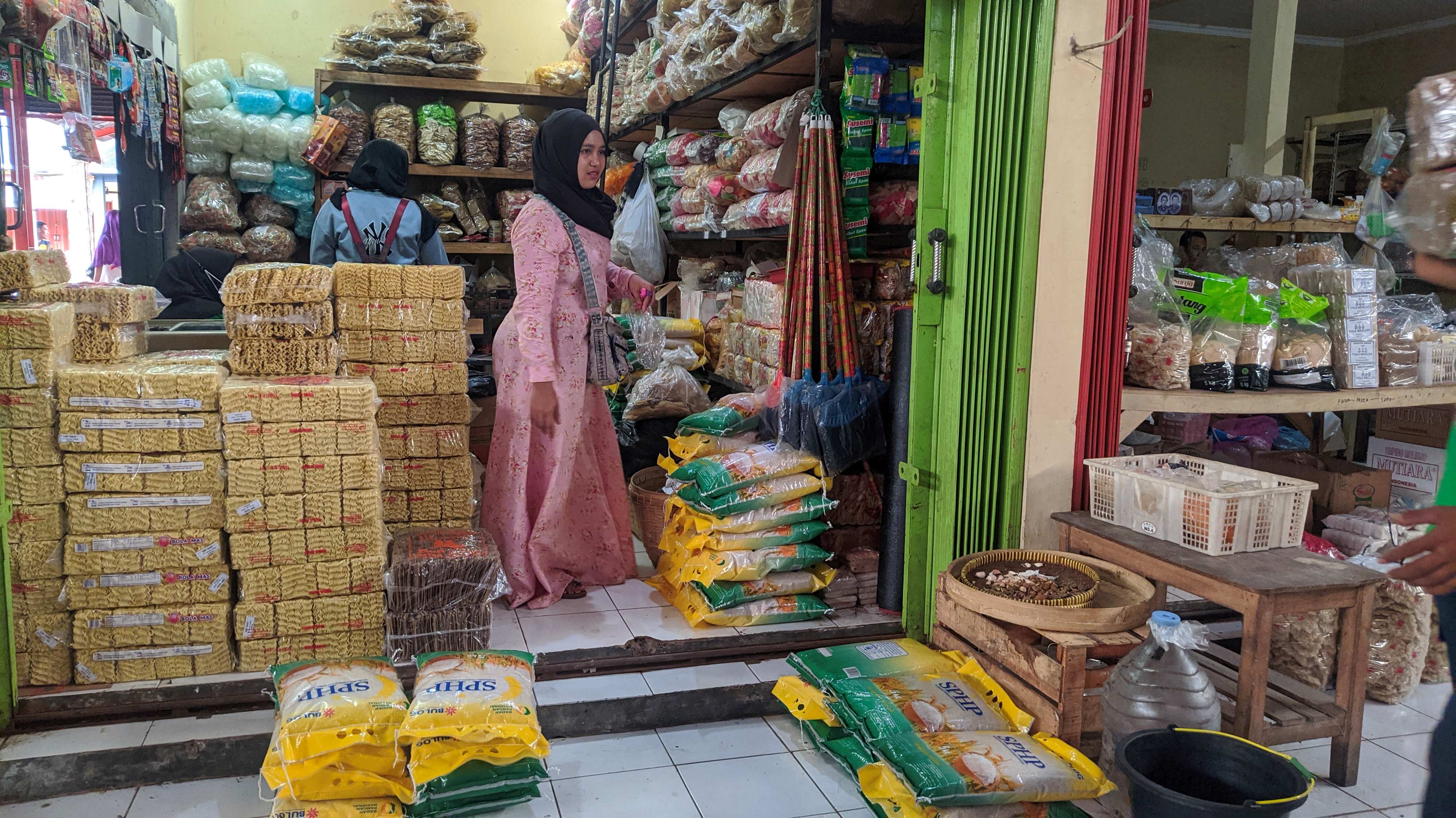 CEK SEMBAKO: Pedagang di Pasar Rakyat Sido Makmur menghitung stok beras yang ada di tokonya.